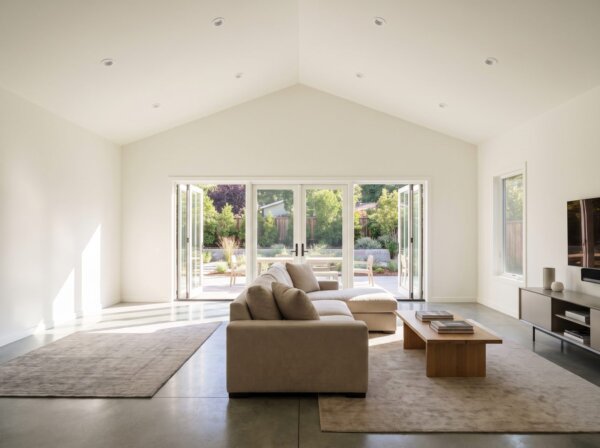 Completed garage conversion with smooth finished drywall walls and recessed lighting